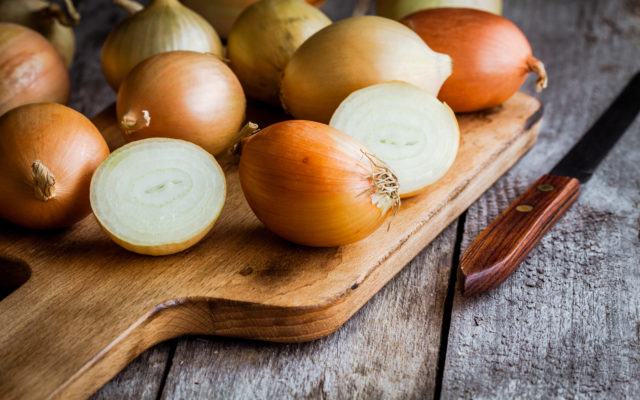 Fresh organic onions on a wooden background